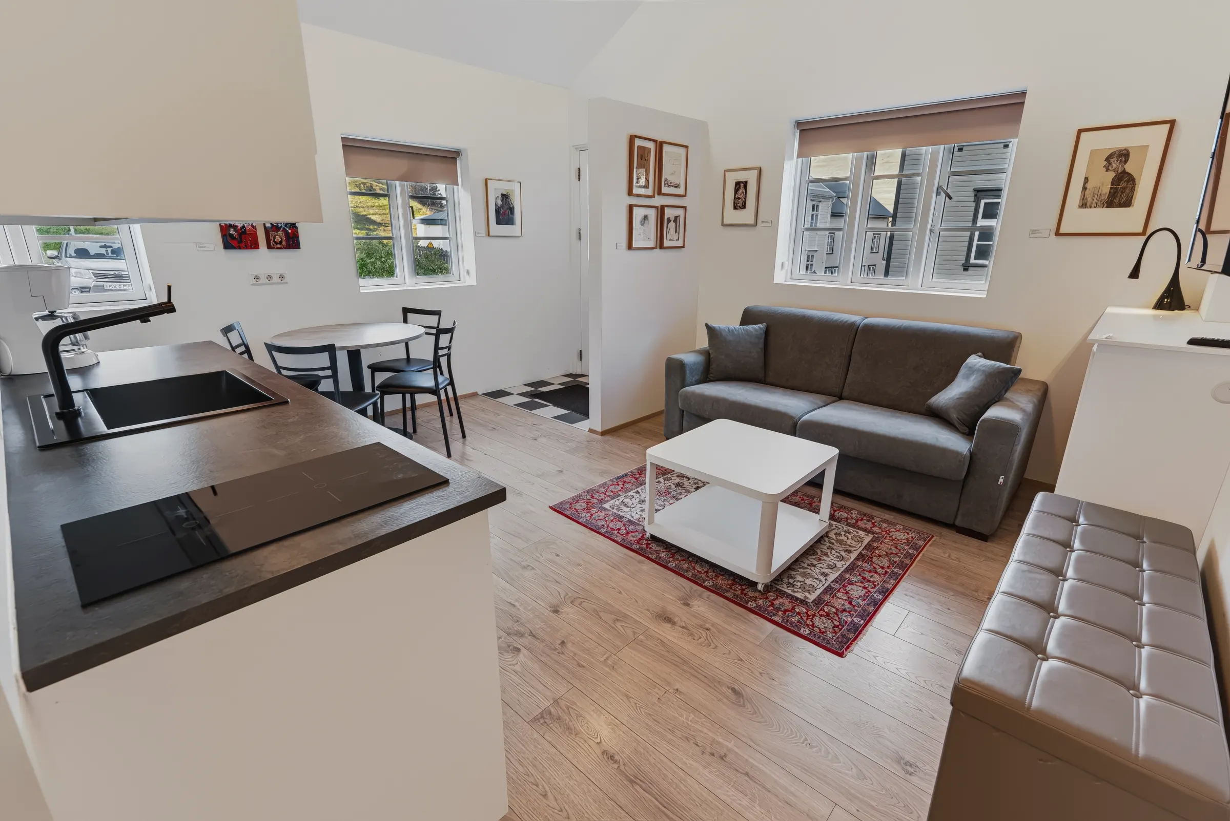 The kitchen and living area of the Cosy Studio, with a grey sofa and a white coffee table