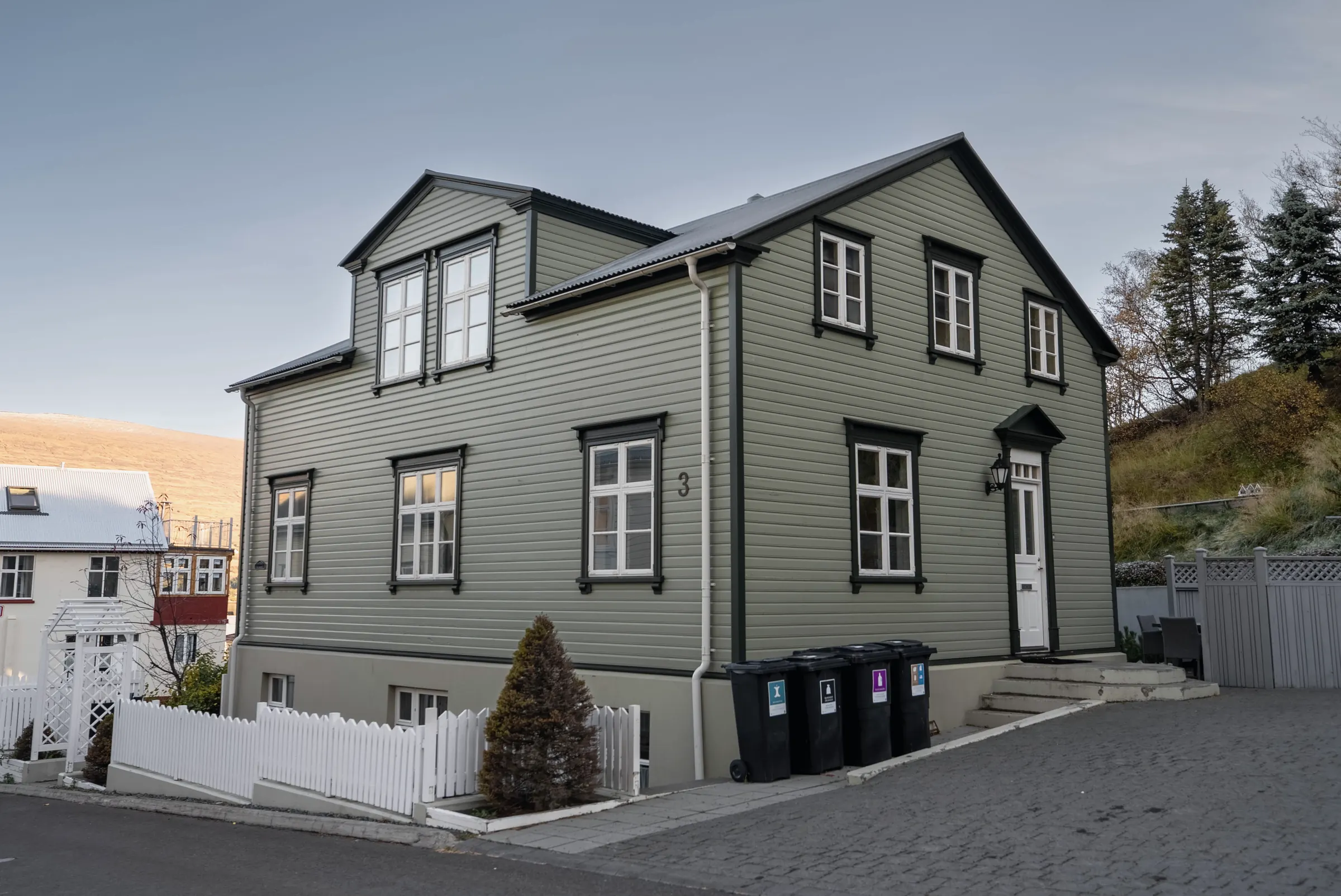 The house at Lækjargata 3 from the street, with its number on the wall and the entrance steps beside the drive