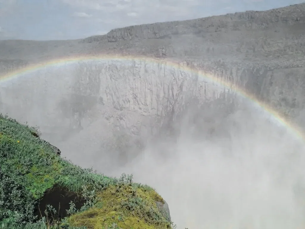 Dettifoss thundering into its canyon under a rainbow of spray